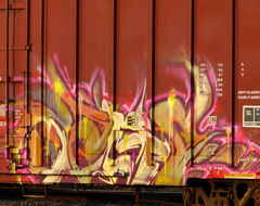 Text art graffiti on the side of a train car, location unknown