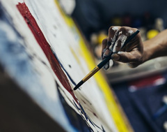 An artist painting on a canvas with a paintbrush
